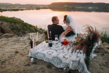 Genç düğün çift siiting mumlarla kum plaj romantik akşam gölde başa