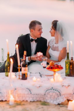 Genç evlilik çift mum kum plaj romantik bir akşam paylaşmak