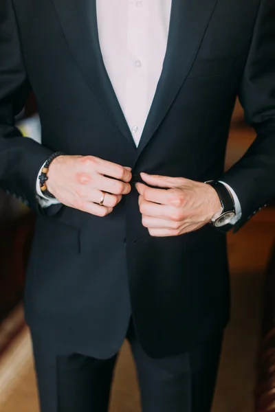 Retrato de un joven elegante negocio cerrando su esmoquin — Foto de Stock