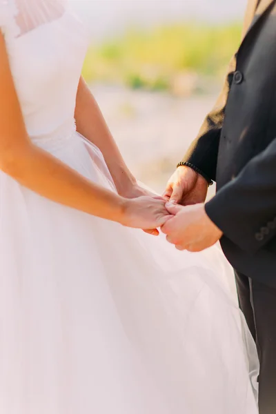Изображение жениха и невесты, держащихся за руки где-то снаружи — стоковое фото