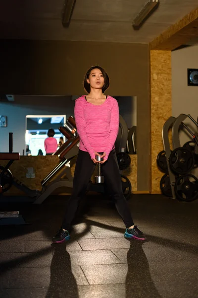 Charmant instructeur de fitness asiatique fille en rose vêtements de sport faire de l'exercice avec haltères à la salle de gym — Photo