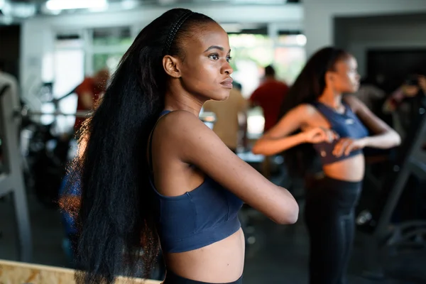 Fitness, sport, dance and lifestyle concept - beautiful black african american woman training in gym or studio