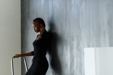 Onun kalın örgü karanlık studio arka plan üzerinde dokunmak çok Afrika veya siyah Amerikalı kadın yan görünüm