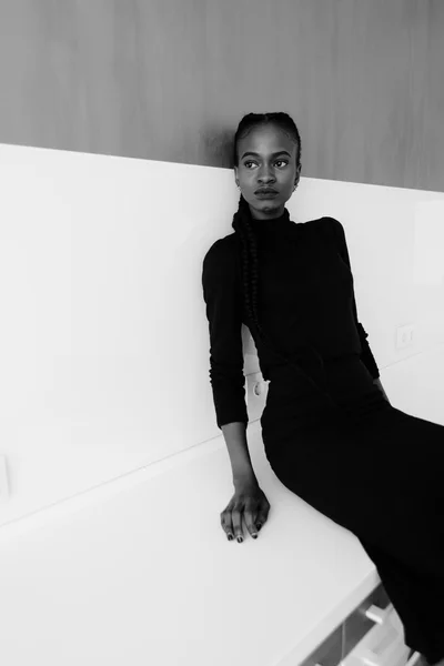 Zwart-wit portret van een ernstige Afrikaanse of zwarte Amerikaanse vrouw boven de grijze achtergrond staan en op zoek weg — Stockfoto