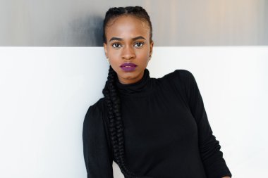 Yakın çekim kamera ayakta, beyaz arka plan üzerinde arıyorsunuz bir ciddi Afrika veya siyah Amerikalı kadın portresi