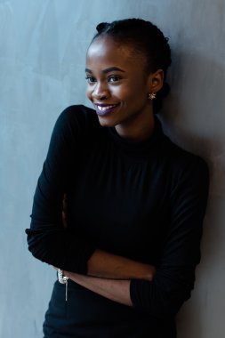 Uzakta gri arka planı arıyorum parlak mor dudaklar ile gülümseyen genç Afrikalı kadın portresi