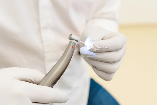 Рука стоматолога в белых латексных перчатках с зубной дрелью с турбиной, крупным планом — стоковое фото