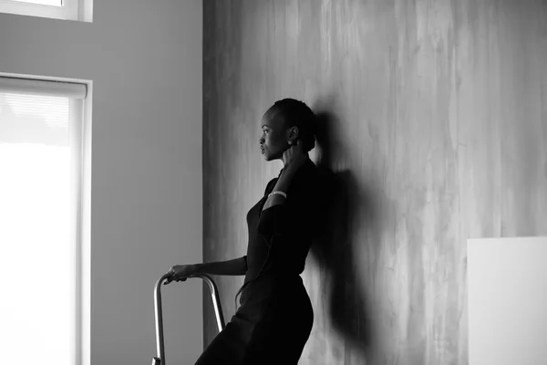 Black-and-white-portrait of pretty african or black american woman touching her thick plait on dark studio background — Stock Photo, Image