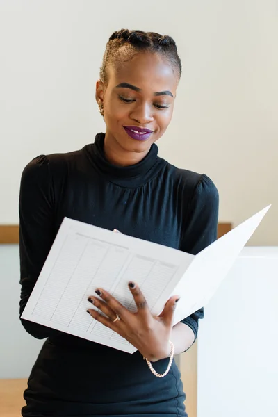 Μεγέθυνση της χαμογελώντας κομψό επαγγελματικό γυναίκα φοράει μαύρο φόρεμα στο φως γραφείο, γράφοντας την Ατζέντα — Φωτογραφία Αρχείου