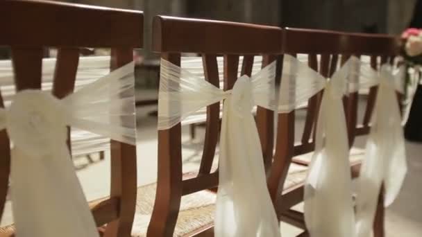 Wedding chairs on the ceremony decorated with white silk bows close up — Stock Video