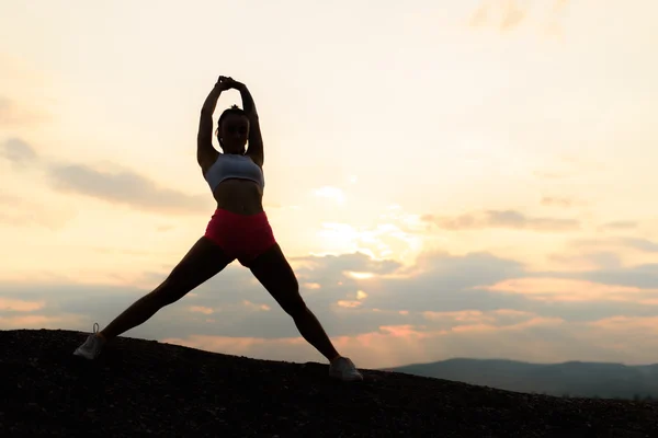 Fitness vrouw uit te oefenen en rekken op mooie zomerse zonsondergang of 's morgens op strand. Vrouwelijke doen ontspannen yoga oefeningen — Stockfoto