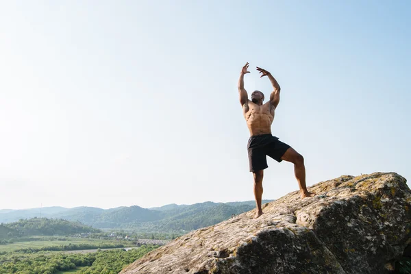 Foto emocional del atleta afroamericano negro en la roca en las montañas. Belleza y perfección del cuerpo humano —  Fotos de Stock