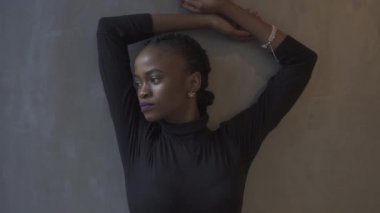 Karanlık studio arka plan üzerinde zarif siyah elbiseli güzel Afro-Amerikan model portresi