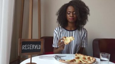 Muhteşem zarif vejeteryan Afrikalı-Amerikalı kadın pizza yok et ile restoranda yemek. İş yemeği
