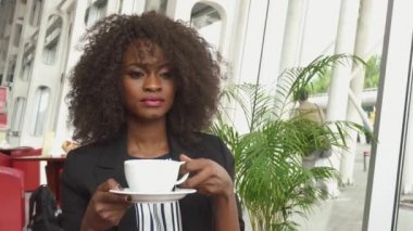 Havaalanında bir uçuş için beklerken kahve içmek çok güzel Afro-Amerikan iş kadını