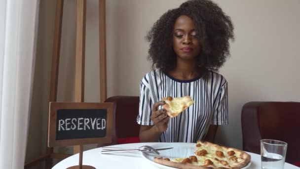 Fabulosa mujer afroamericana vegetariana elegante comiendo pizza sin carne en el restaurante. Almuerzo de negocios — Vídeos de Stock
