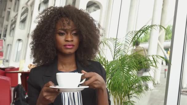 Linda senhora de negócios afro-americana bebendo café no aeroporto enquanto espera por um voo — Vídeo de Stock