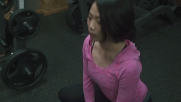 Unga attraktiva asiatisk tjej gör övning med hantlar på gymmet — Stockvideo