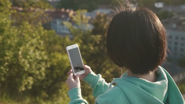 Fiatal csinos ázsiai nő csinál szelfi szabadban a parkban használja a telefonját — Stock videók
