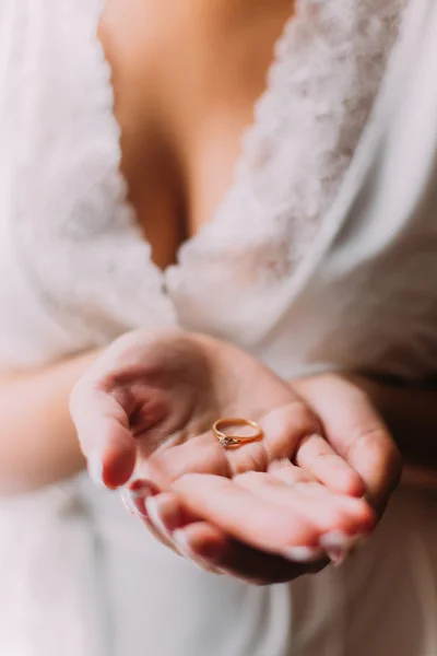 Красивая молодая женщина держит кольцо на открытой ладони — стоковое фото