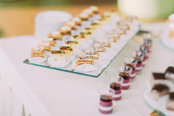 Buffet de postres con deliciosa pastelería de chocolate dulce en mantel blanco como la nieve. Primer plano —  Fotos de Stock