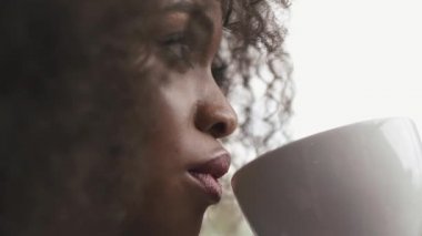 Büyük güzel Afro-Amerikan iş kadını kafede beyaz fincan kahve içme close-up