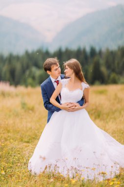 Mutlu oynak düğün çift orman arka plan ile güneşli alan üzerinde