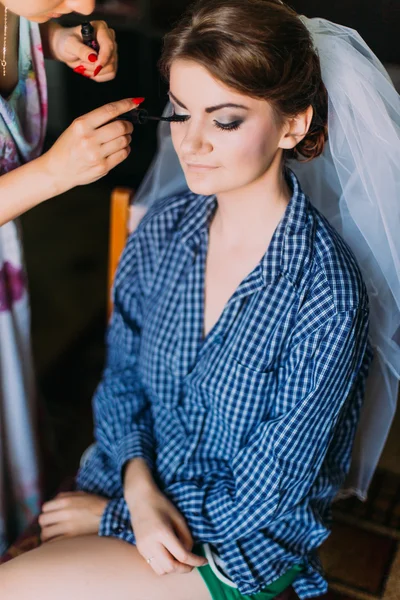 Huwelijk moment van de dag. Toepassing van make-up voor mooie jonge bruid in kleedkamer — Stockfoto