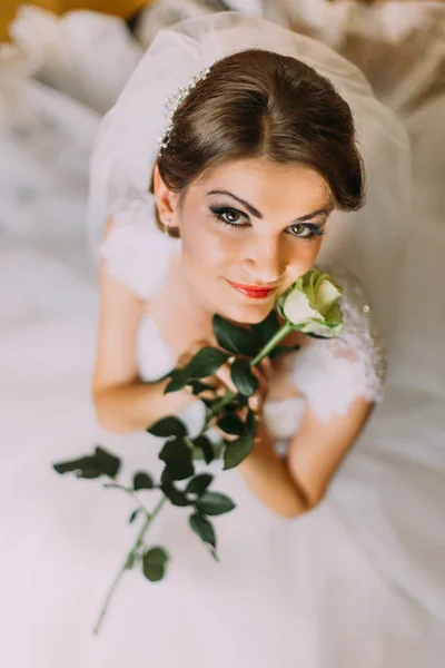 Delicato rosa nelle mani di giovane ragazza vestita abito da sposa bianco — Foto Stock