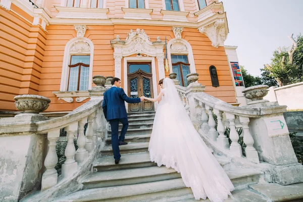 Casal jovem bonito andando nas escadas do palácio antigo romântico — Fotografia de Stock