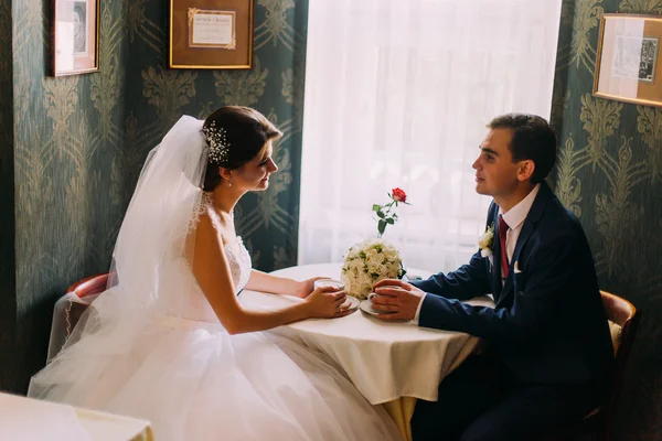 Novia y novio bebiendo café en un lindo café después de su boda —  Fotos de Stock