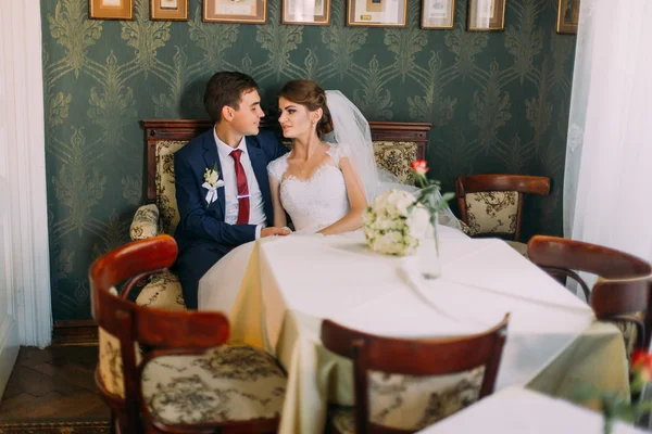 Recém-casados sentados à mesa no café retro após o casamento — Fotografia de Stock