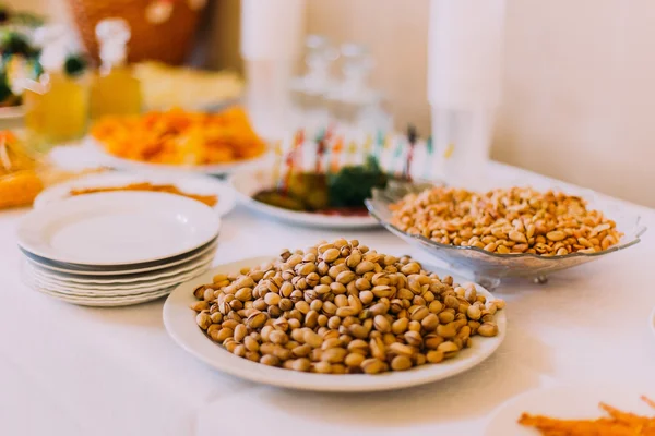 Zoute pinda's en pistachenoten op de luxe catering tafel geserveerd — Stockfoto