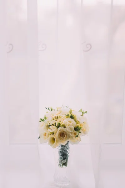 Szép csokor virágot a csiszolt üveg váza, ablakpárkányon. Világos ablak függöny fehér háttér — Stock Fotó