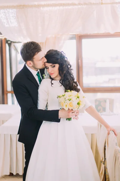 Bela noiva elegante e abraço do noivo no interior do restaurante luxuoso — Fotografia de Stock