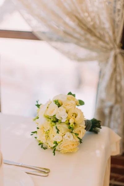 테이블 코너에 흰색 식탁보에 노란색 장미의 신부 꽃다발 — 스톡 사진