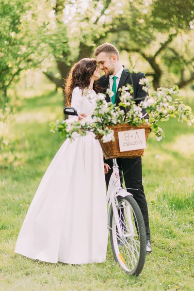 官能的な若い新婚夫婦は、派手な装飾された自転車で公園でポーズ — ストック写真