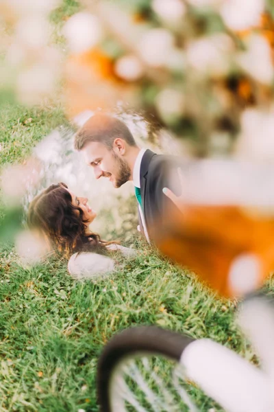 Giovani sposi felici nel parco. Coppia romantica riflessa nello specchio della bicicletta — Foto Stock