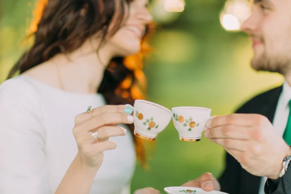 Стильна молода пара насолоджується чаєм в зеленому саду — стокове фото