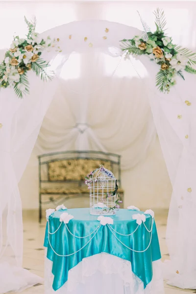 Gaiola de pássaro decorativa bonita na mesa decorada fantasia sob arco de casamento isolado no interior do vintage stylysh — Fotografia de Stock