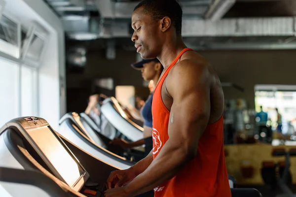 Black african american bodybuilder training on the treadmill in gym Stock Image