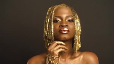 Stüdyo portre olan stilist ile çekim için altın Faceart Preapring gerçeküstü Afrikalı-Amerikalı kadın. Yaratıcı Vogue kavramı
