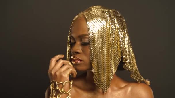 Studiový portrét tajemné africké americké ženy s Golden Preapring společnosti Faceart pro střelbu s stylista. Kreativní koncept neskutečný — Stock video