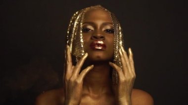 Siyah Studio Arka Plan Poz Parlak Altın Makyaj ve Şapka ile Seksi Afrikalı Amerikalı Kadın Gerçeküstü Portre. Bronz Bodypaint