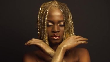 Afrikalı-Amerikalı kadın modeli altın parlak şapkalar ile gerçeküstü moda portre. Yaratıcılık kavramı, siyah stüdyo arka plan