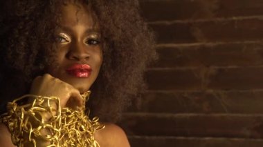 Güzel genç Afro-Amerikan kadın model altın parlak makyaj ile. Yüz sanat. Siyah stüdyo arka plan