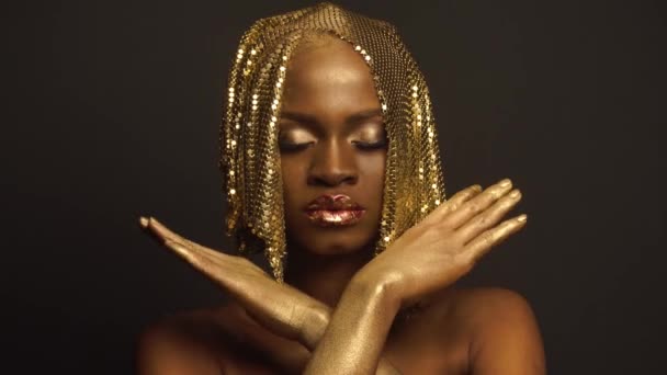 Surrealistisch Fashion Portret van Afro-Amerikaanse vrouwelijke Model met gouden glanzend hoofddeksels. Creatieve Vogue Concept, zwarte Studio achtergrond — Stockvideo