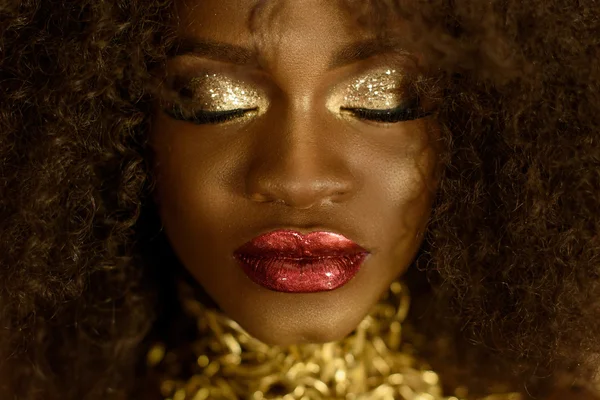 Surrealistisch close-up portret van jonge Afro-Amerikaanse vrouwelijke model met gouden glanzend make-up. Gezicht art. Fashion concept — Stockfoto
