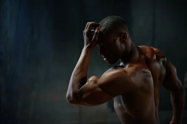 Retrato. Africano americano construtor de corpo masculino posando em um fundo estúdio preto. Beleza e perfeição do corpo humano — Fotografia de Stock