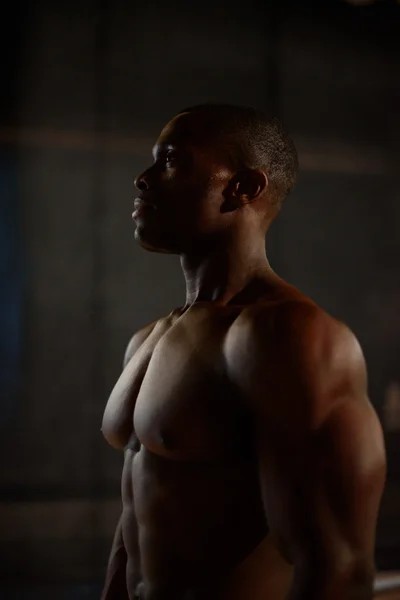 검은 배경에 스튜디오에서 근육을 보여주는 아프리카계 미국인 보디 모델 — 스톡 사진